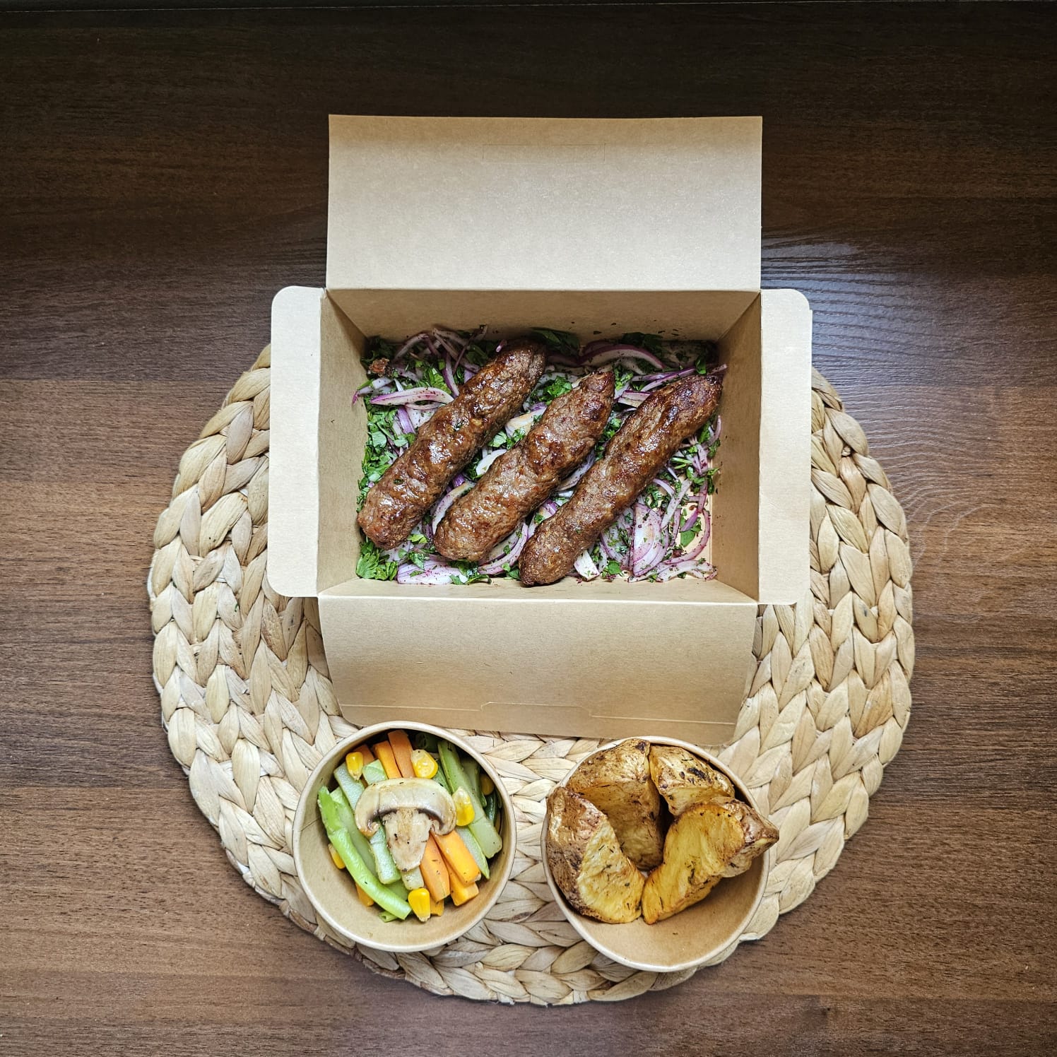 Grilled meat kofta with potato wedges and sautéed vegetables