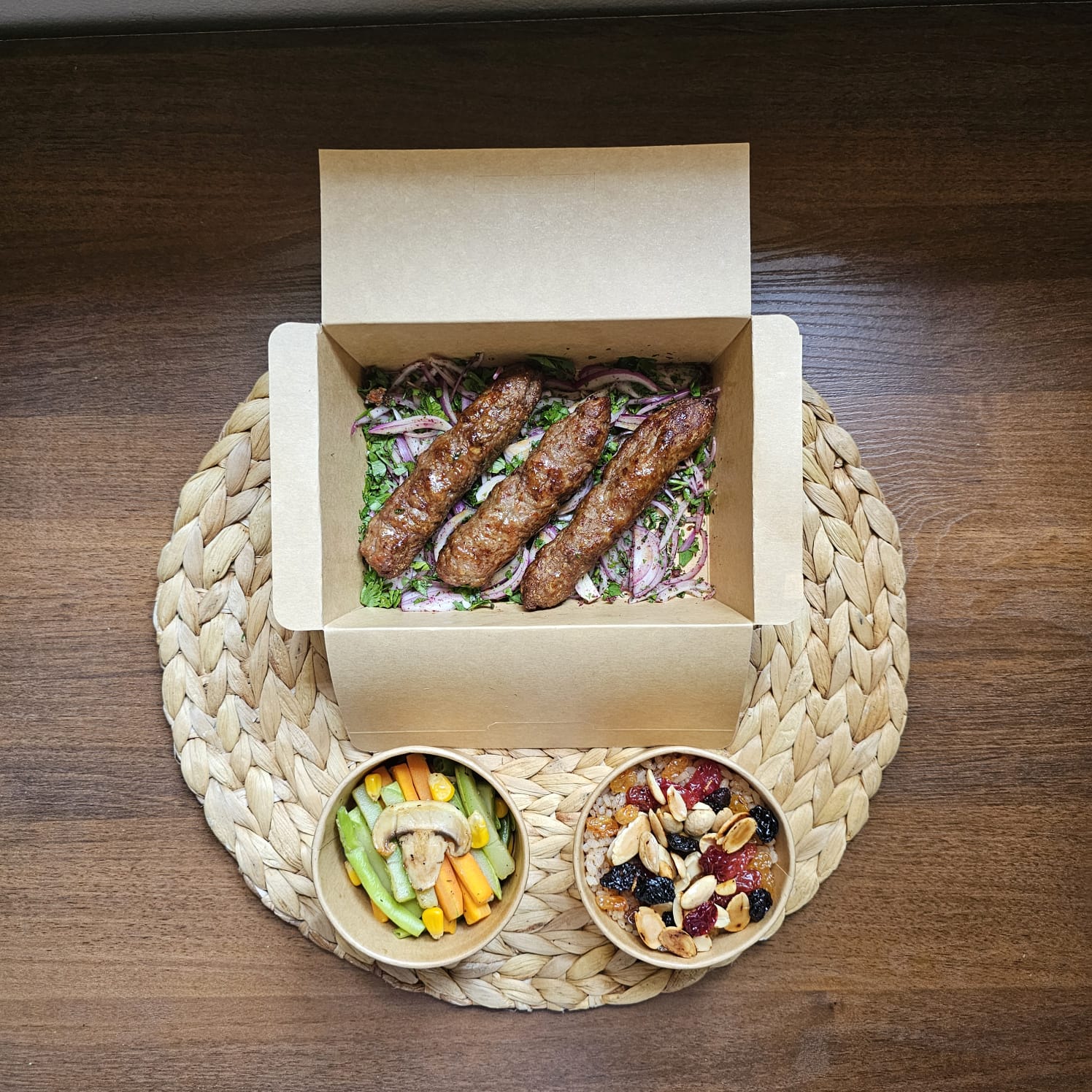 Grilled meat kofta served with cinnamon rice (topped with raisins & almonds) and sautéed vegetables