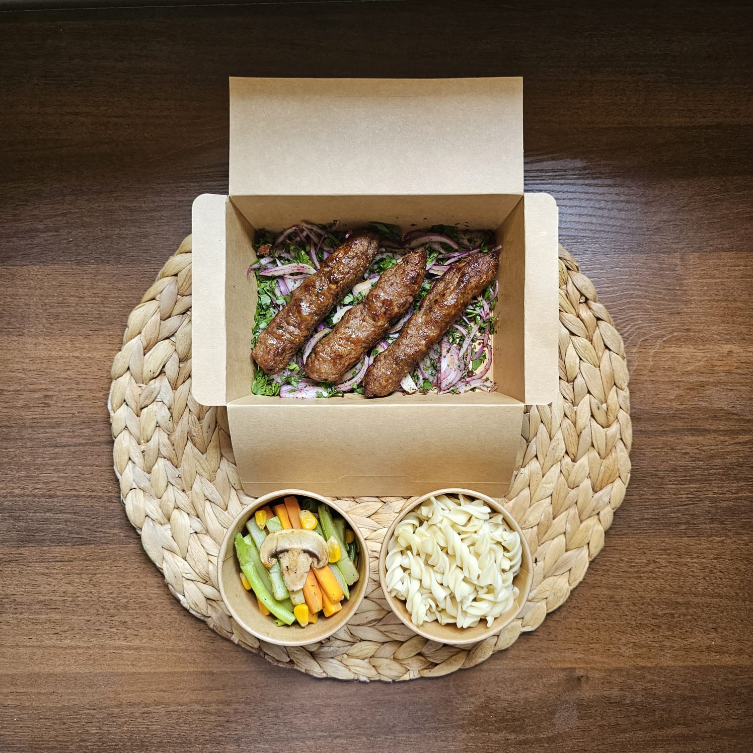 Grilled meat kofta served with plain pasta and sautéed vegetables